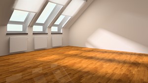 fotografía habitación amplia, vacía, con ventanas, pintada color blanco con parquet de madera color mel